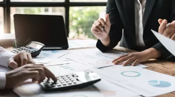 Mehrere Personen, die am Tisch sitzen und etwas besprechen.