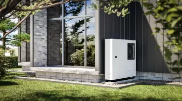 An der Wand eines Einfamilienhauses installierte Wärmepumpe mit erneuerbaren Energiequellen